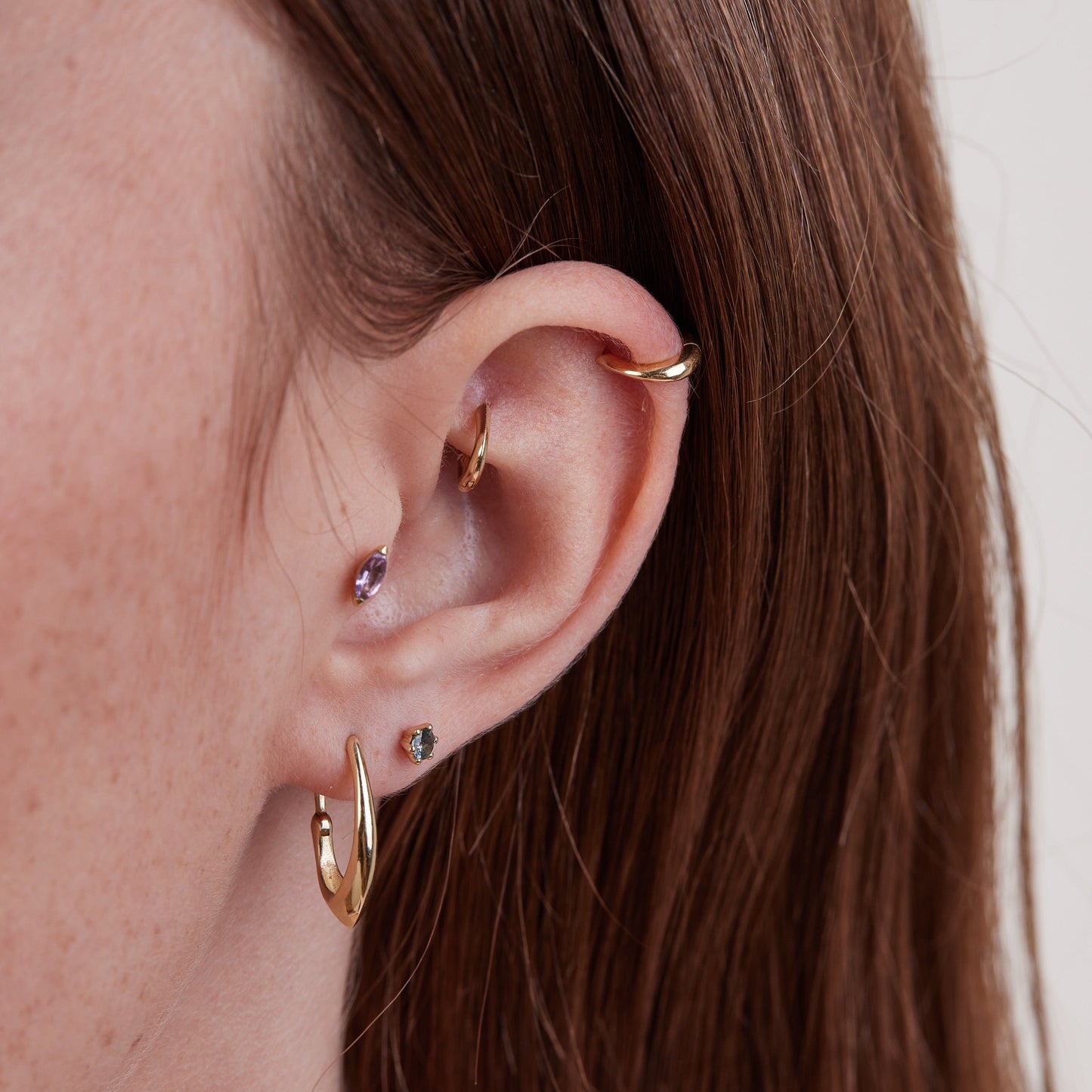 Square piercing with a round stone